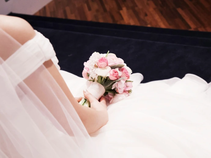 a woman in a wedding dress holding a bouquet of flowers