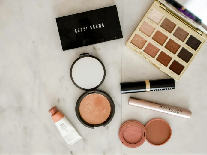 photo of assorted makeup products on gray surface